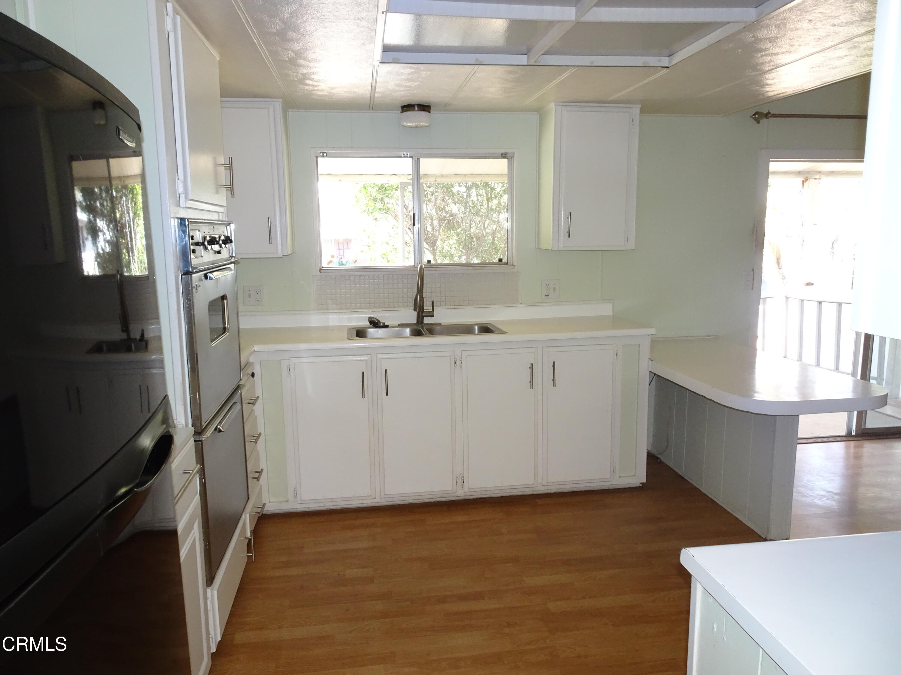 1225 South Rice Road, Unit 28 Ojai, CA 93023 - Photo 16 of 27 a kitchen with a sink a stove cabinets and wooden floor