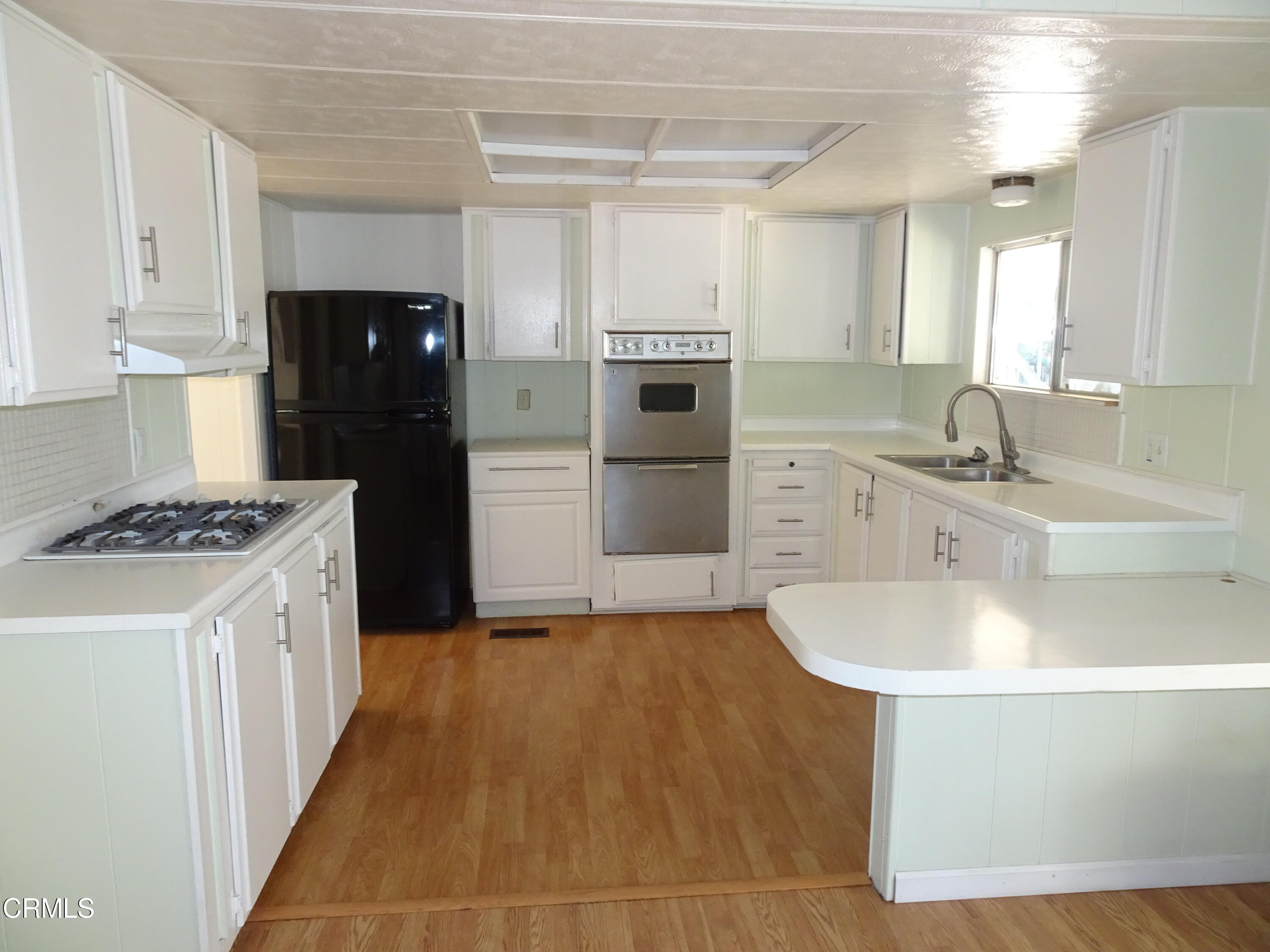 1225 South Rice Road, Unit 28 Ojai, CA 93023 - Photo 17 of 27 a kitchen with kitchen island a sink appliances and cabinets