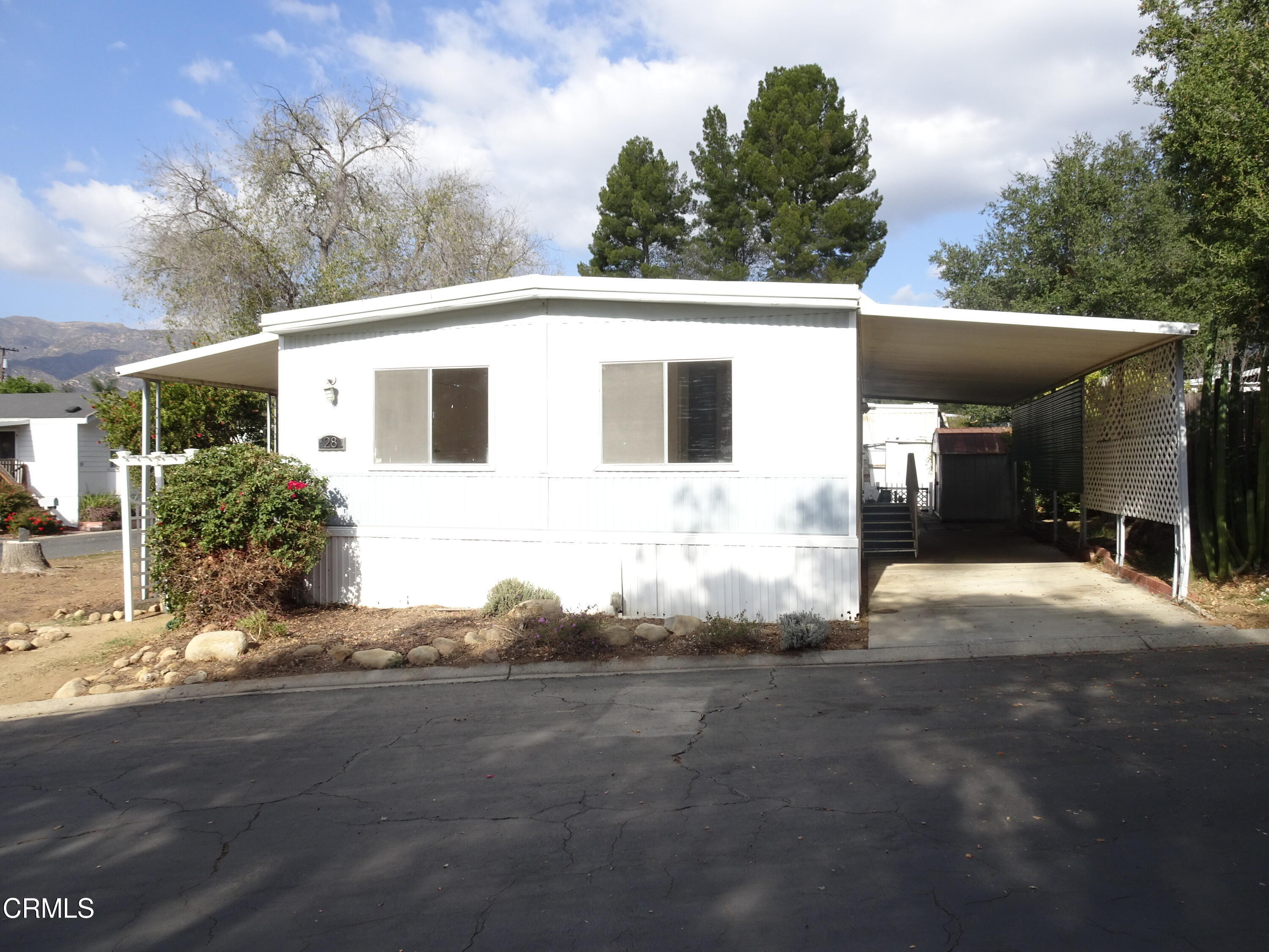 1225 South Rice Road, Unit 28 Ojai, CA 93023 - Photo 2 of 27 a front view of a house with a yard and garage