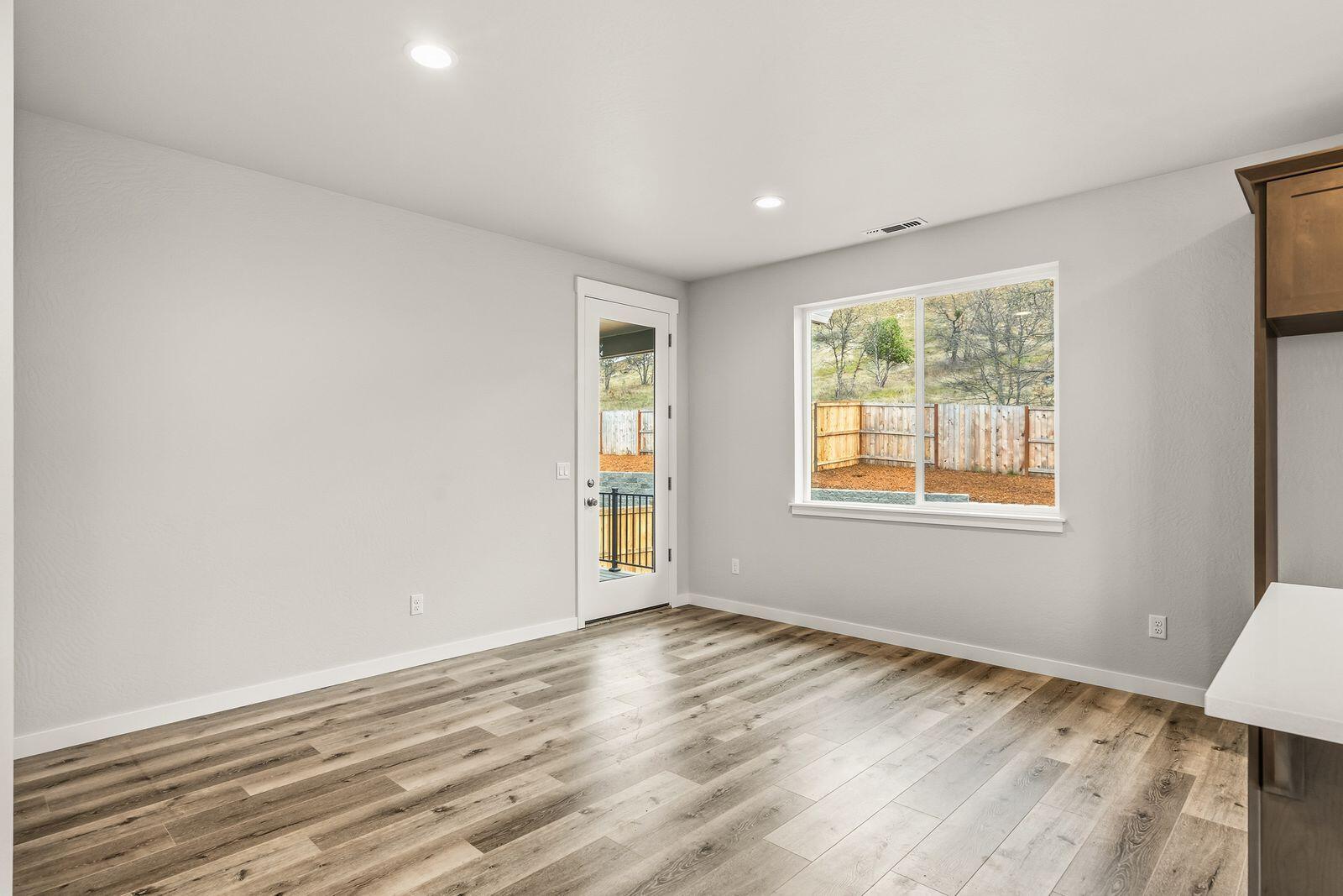 669 Old Waverly Way, Unit 20 Eagle Point, OR 97524 - Photo 8 of 32 a view of an empty room with wooden floor and a window