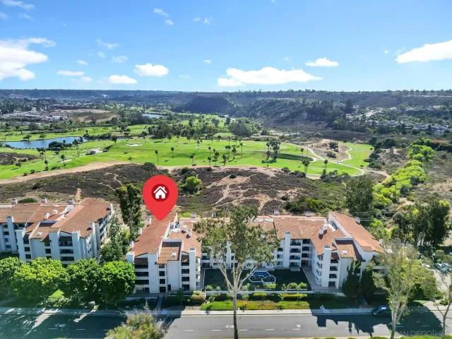 an aerial view of residential houses with outdoor space and parking