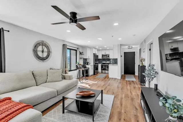 a living room with furniture kitchen view and a window