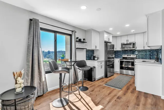 a kitchen with a table chairs refrigerator and microwave