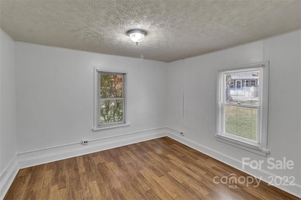 206 Star Ridge Road Canton, NC 28716 - Photo 19 of 29 a view of an empty room with a window and wooden floor