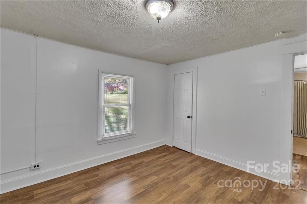 206 Star Ridge Road Canton, NC 28716 - Photo 20 of 29 a view of an empty room with wooden floor and a window