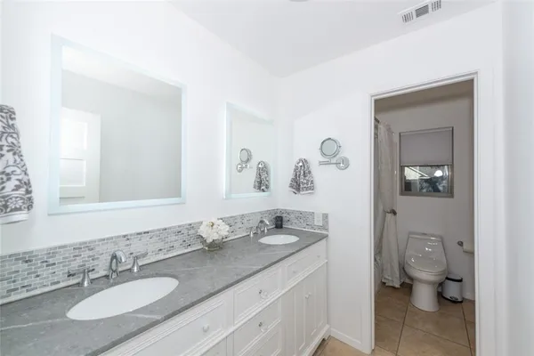 a bathroom with a granite countertop sink mirror and toilet