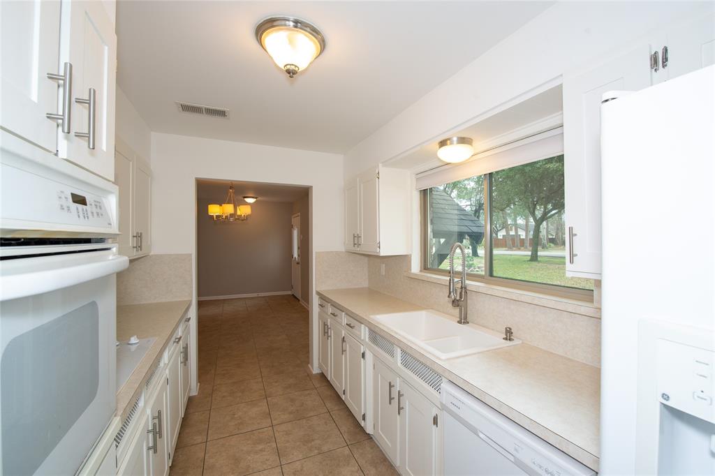 2124 Ridge Lane Grapevine, TX 76051 - Photo 5 of 17 Kitchen featuring white appliances, white cabinetry, light countertops, and light tile patterned flooring