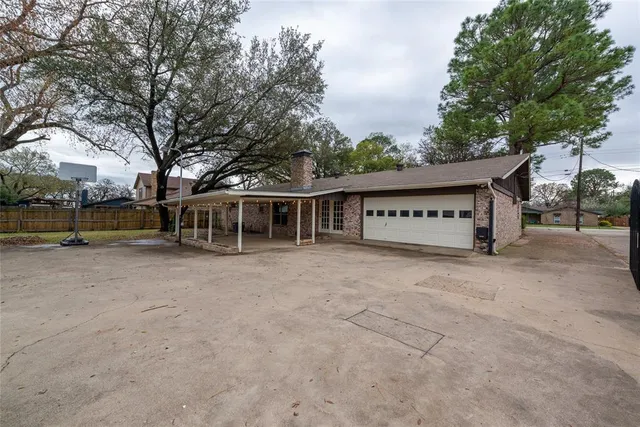 a view of a house with a yard and a large tree