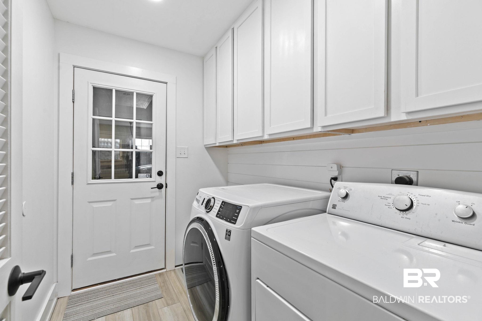 520 Juniper Place Drive Foley, AL 36535 - Photo 26 of 35 Laundry area featuring white shaker-style cabinetry, wood-finish flooring, and white shiplap-style wall paneling