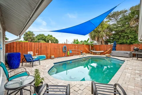 a backyard of a house with dining table and chairs
