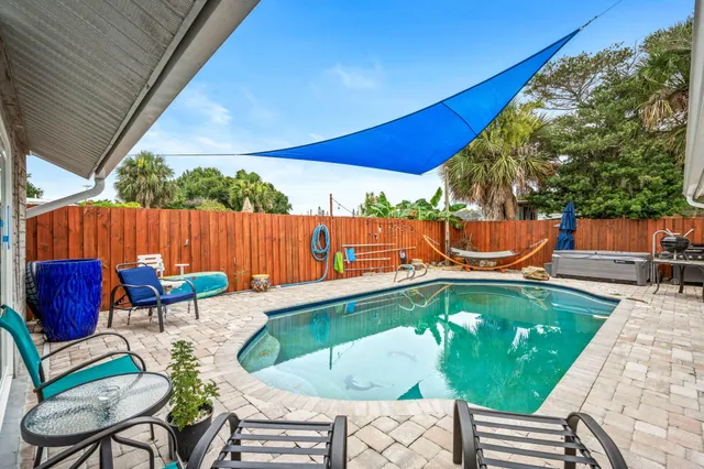 a backyard of a house with dining table and chairs
