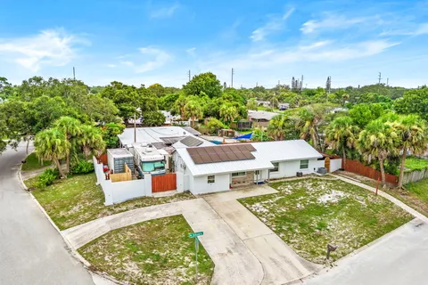 an aerial view of residential houses with outdoor space and trees