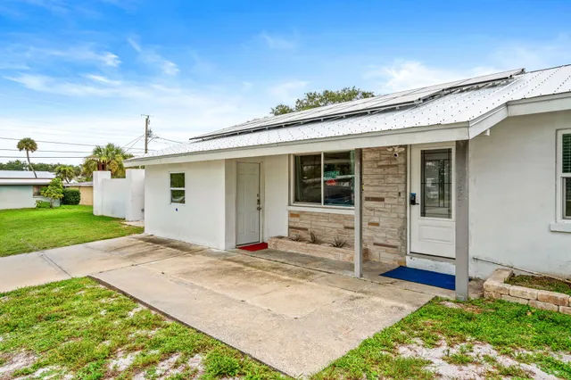an aerial view of residential houses with outdoor space and trees