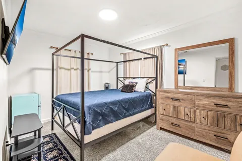 a bedroom with a bed window and a dresser
