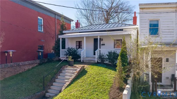 a view of a house with brick walls and a yard with plants