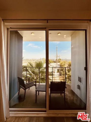 a view of a room with wooden floor and outdoor seating