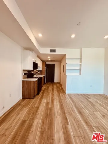 a open kitchen with kitchen island stainless steel appliances a sink window and cabinets