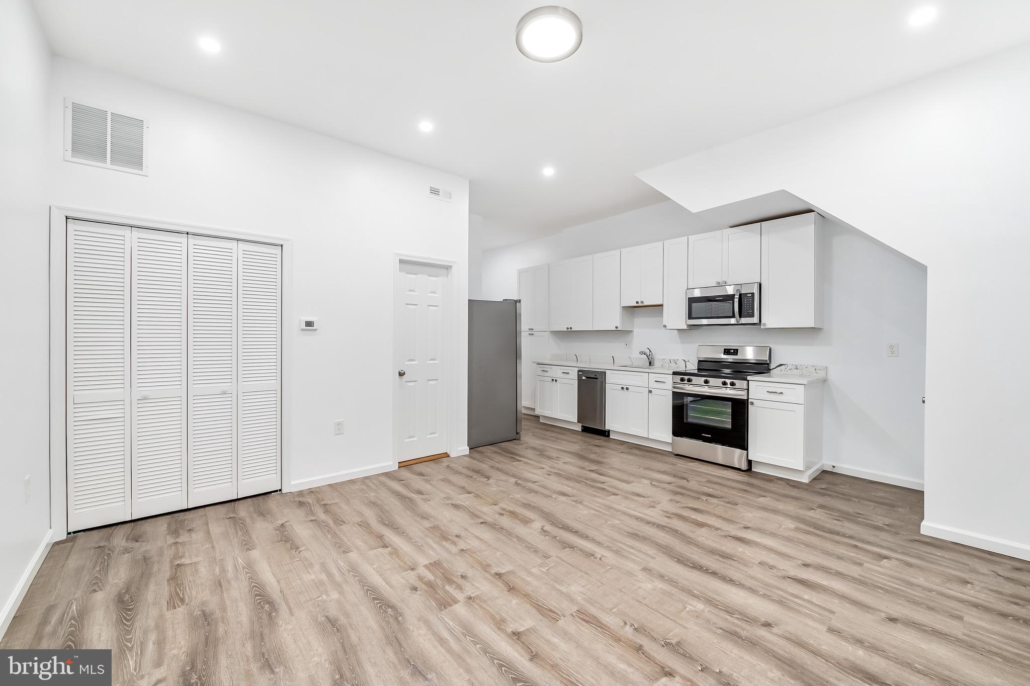 665 Washington Boulevard Baltimore, MD 21230 - Photo 5 of 21 a large kitchen with kitchen island a sink a stove a refrigerator and white cabinets