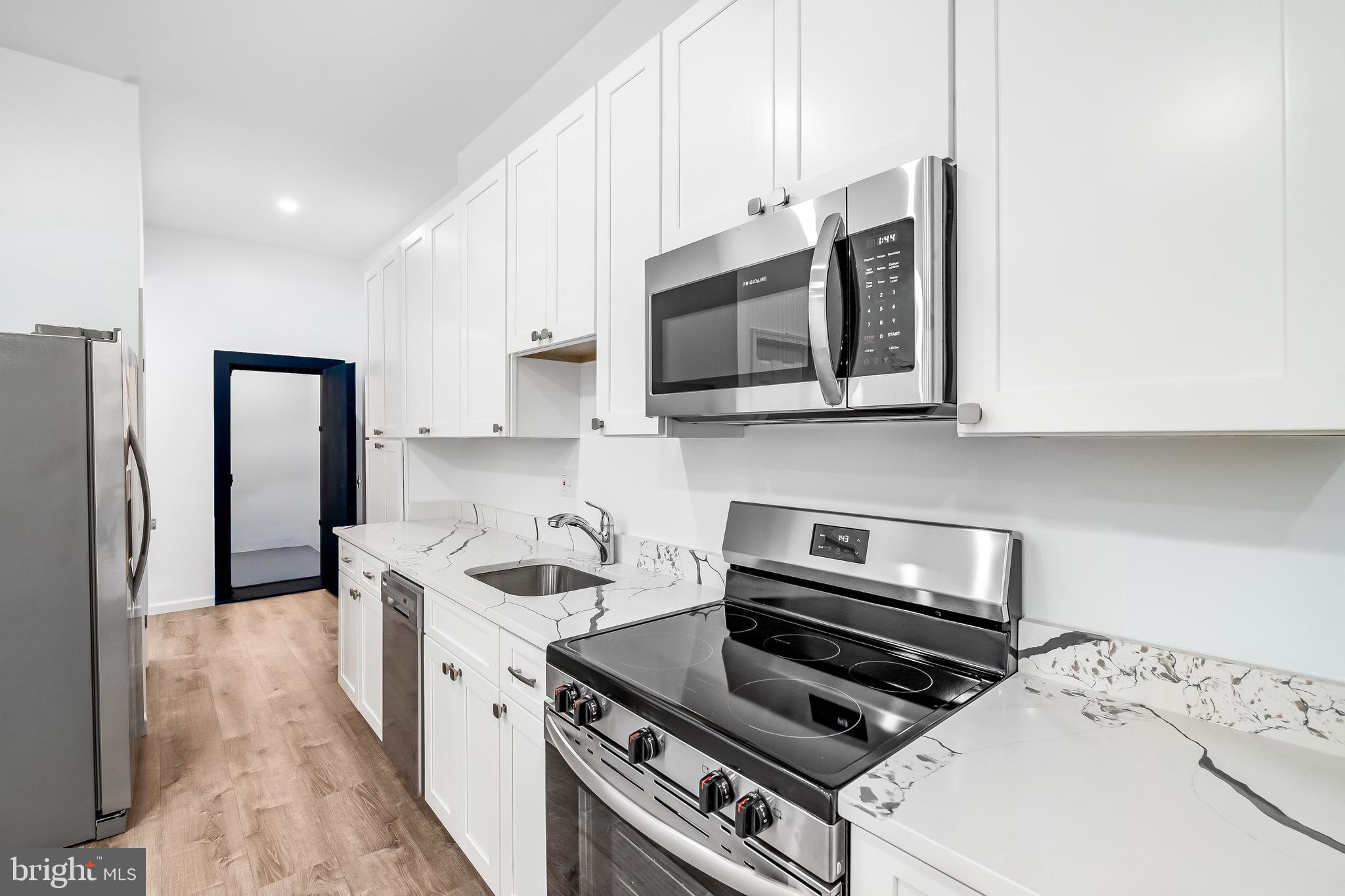 665 Washington Boulevard Baltimore, MD 21230 - Photo 6 of 21 a kitchen with stainless steel appliances a stove a microwave and a sink