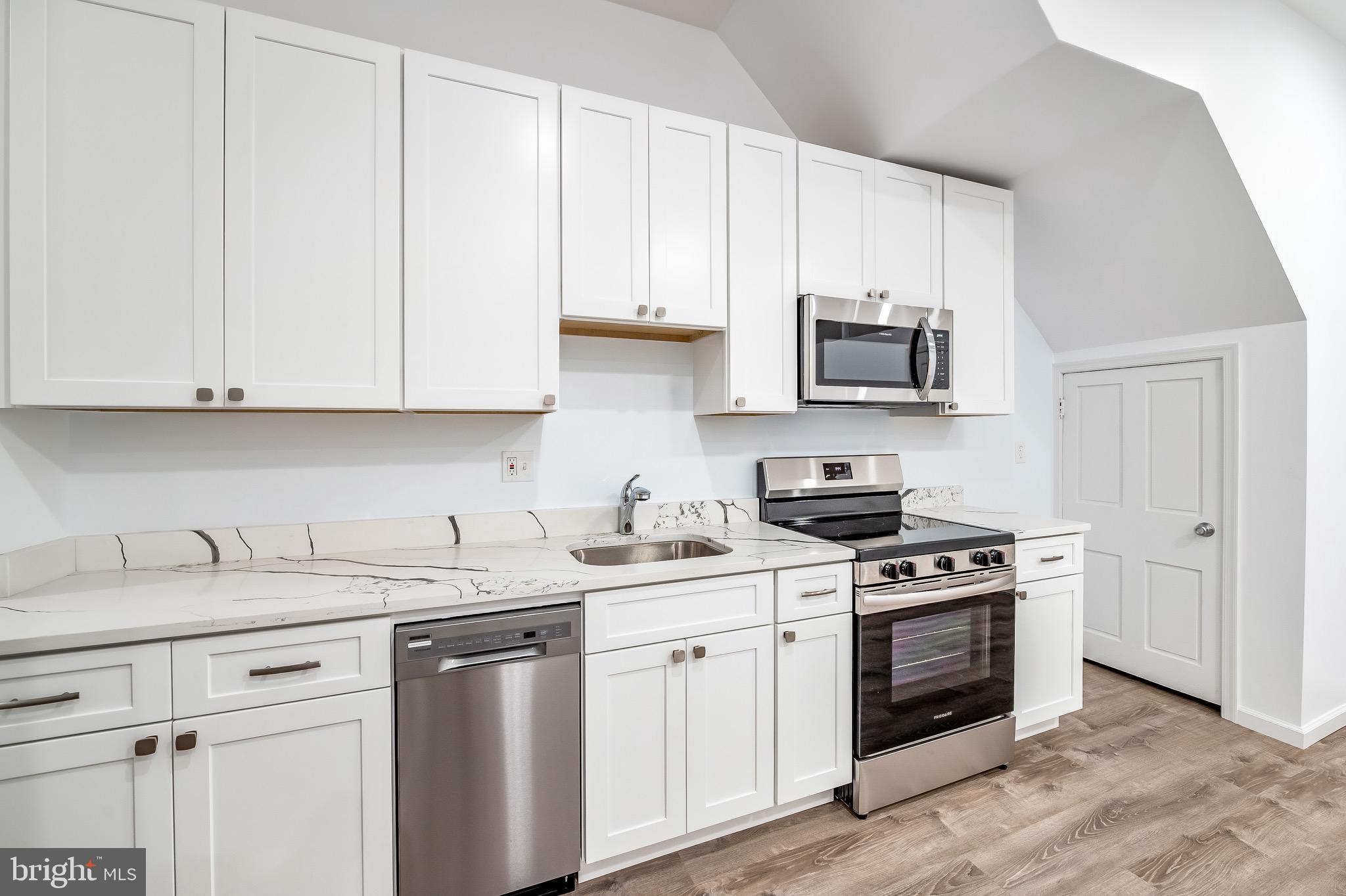665 Washington Boulevard Baltimore, MD 21230 - Photo 7 of 21 a kitchen with stainless steel appliances granite countertop a sink a stove and a microwave