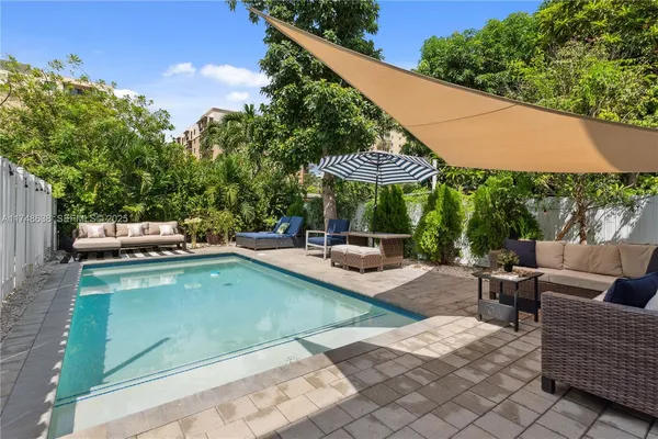 a view of swimming pool with outdoor seating and plants