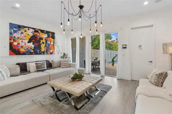 a living room with furniture a couch and a large window