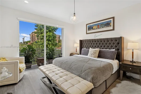 a bedroom with a large bed and a potted plant