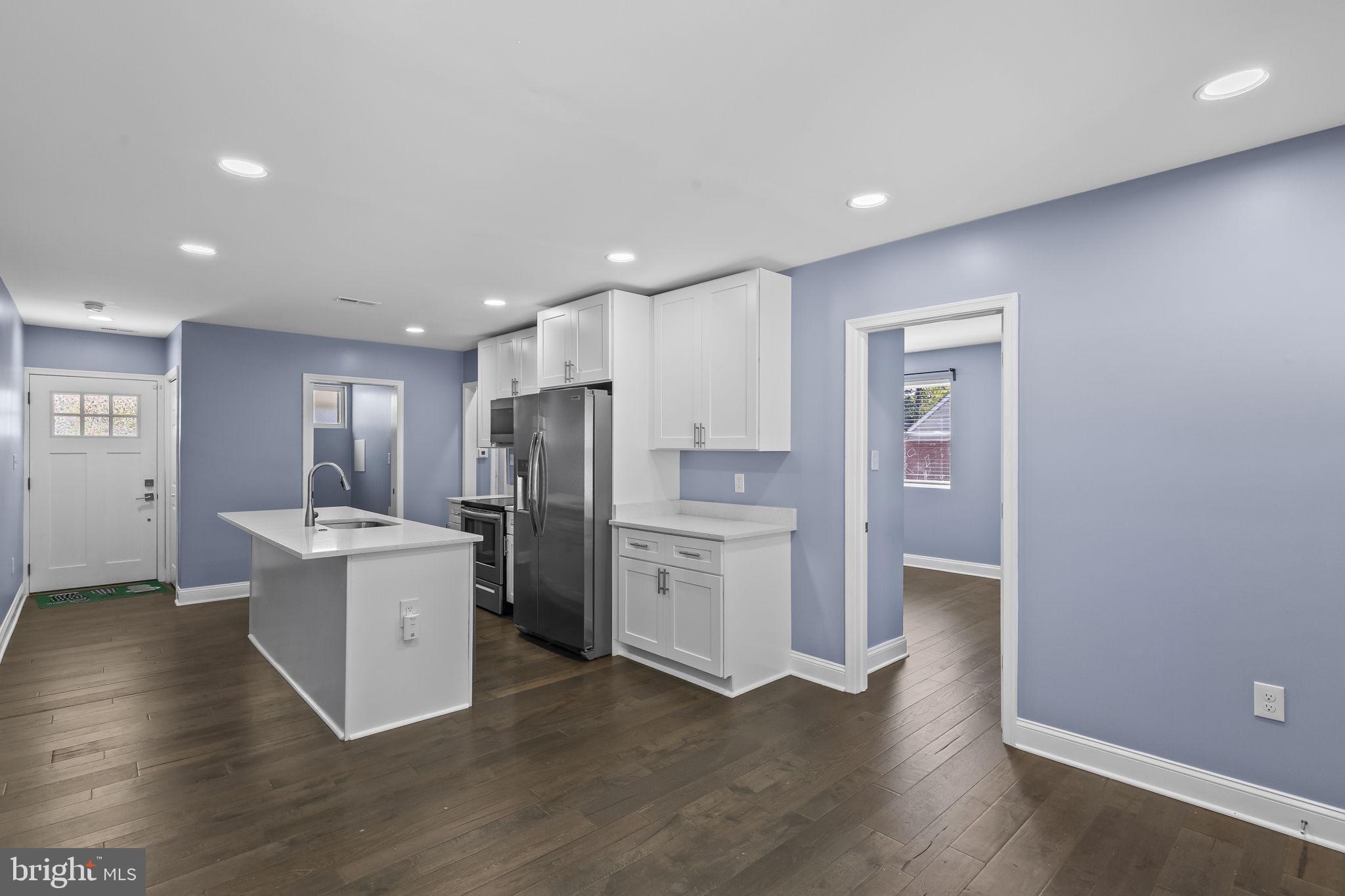 7602 Oxman Road Landover, MD 20785 - Photo 4 of 17 a open kitchen with white cabinets and stainless steel appliances