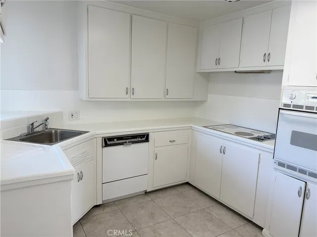 a kitchen with white cabinets and white appliances