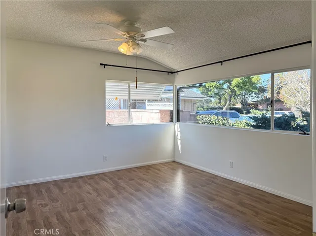 a view of a big room with wooden floor and windows