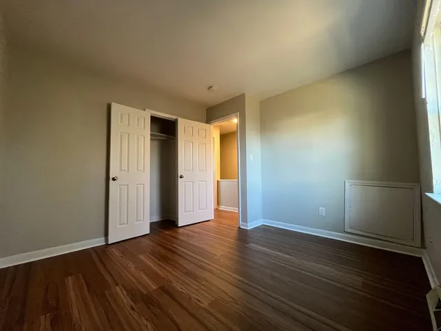 a view of an empty room with wooden floor