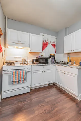a kitchen with granite countertop a stove and cabinets