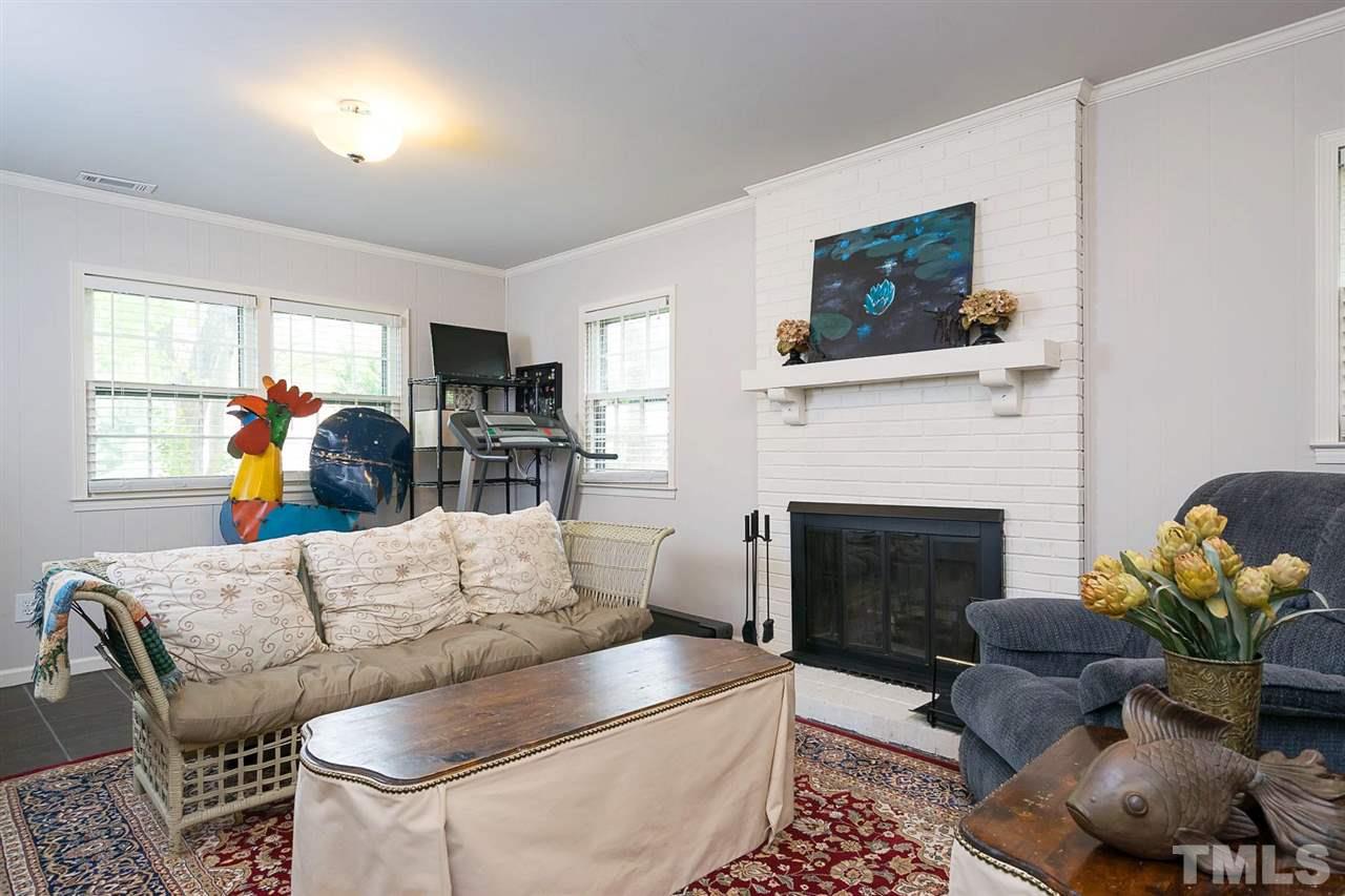 7713 Prospector Place Raleigh, NC 27615 - Photo 11 of 18 a living room with furniture a flat screen tv and a fireplace
