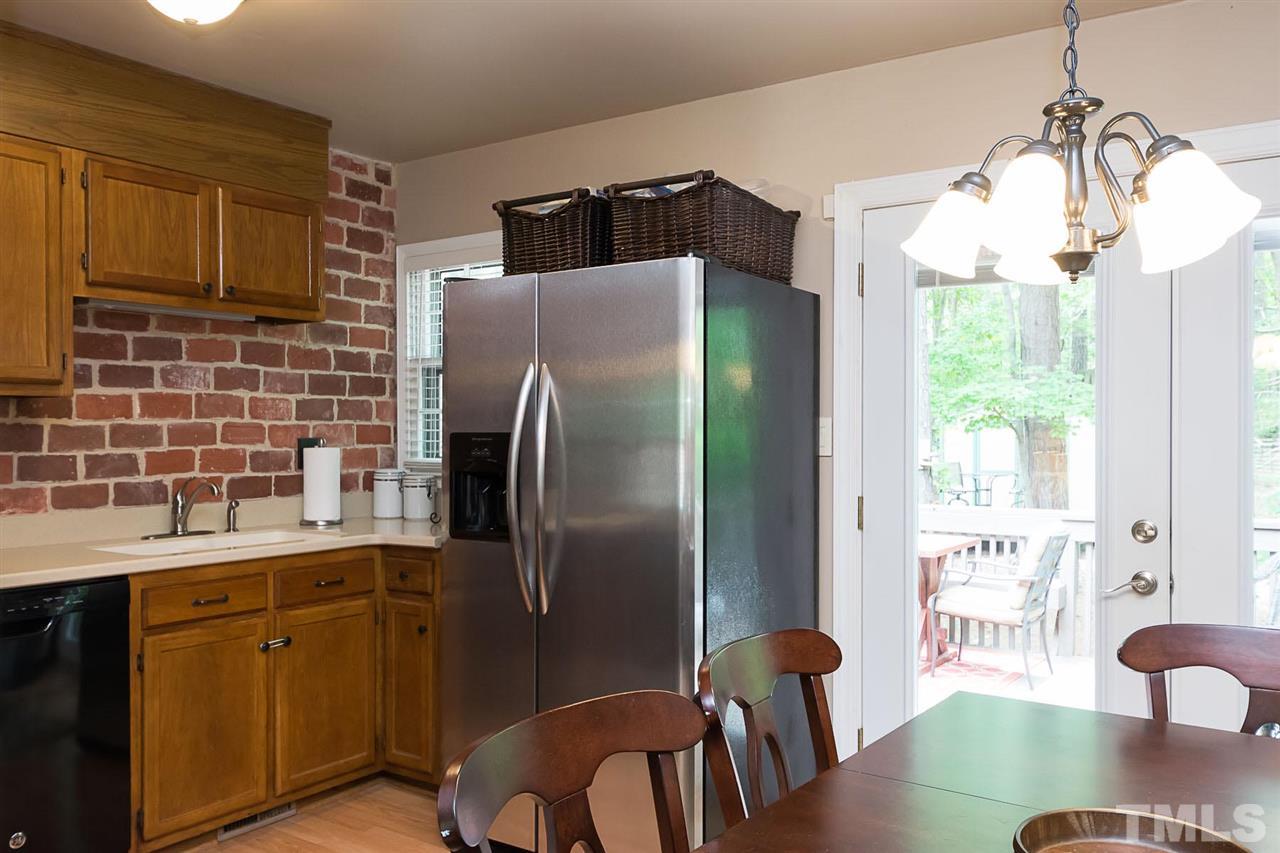 7713 Prospector Place Raleigh, NC 27615 - Photo 6 of 18 a kitchen with stainless steel appliances granite countertop a refrigerator a stove a sink a dining table and chairs