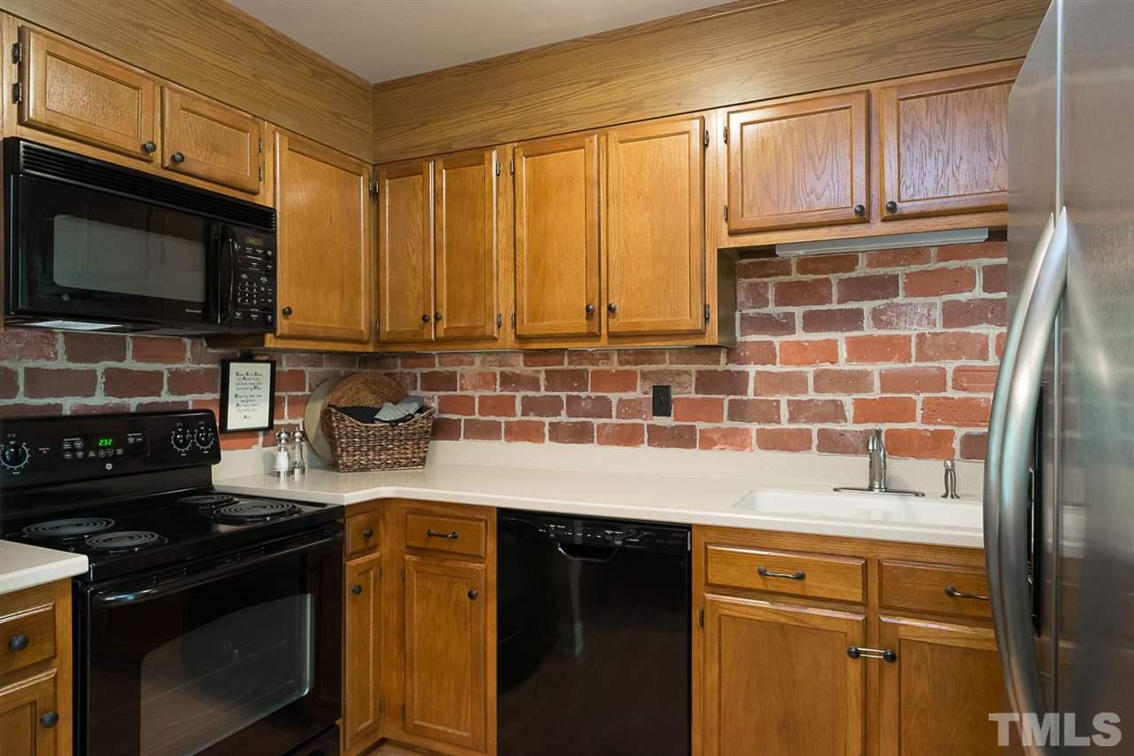 7713 Prospector Place Raleigh, NC 27615 - Photo 7 of 18 a kitchen with granite countertop a stove top oven microwave and cabinets