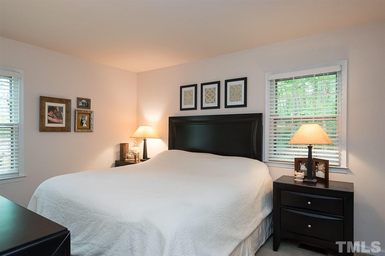 7713 Prospector Place Raleigh, NC 27615 - Photo 9 of 18 a bedroom with a bed and a lamp on dresser