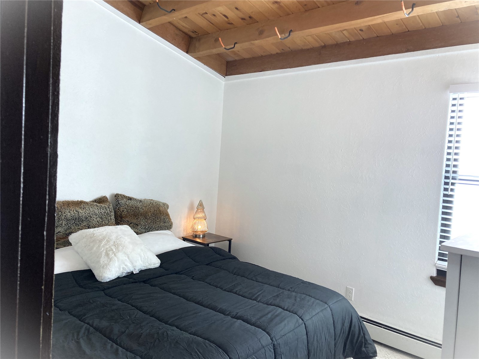 8500 Ryan Gulch Road, Unit 301 Silverthorne, CO 80498 - Photo 22 of 49 a bed sitting in a bedroom next to a window