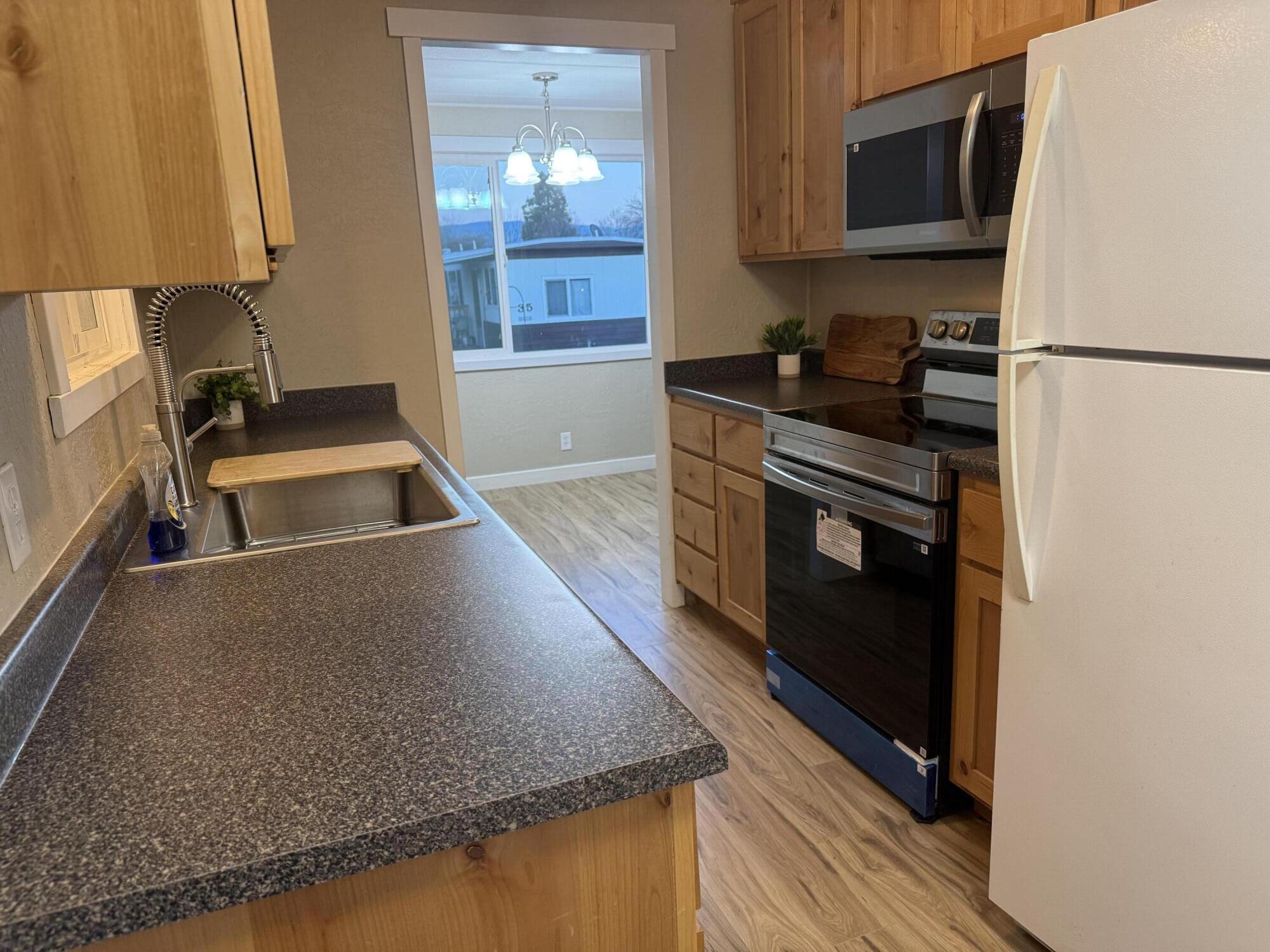 355 Colver Road, Unit 48 Talent, OR 97540 - Photo 16 of 30 a kitchen with stainless steel appliances granite countertop a sink stove and microwave