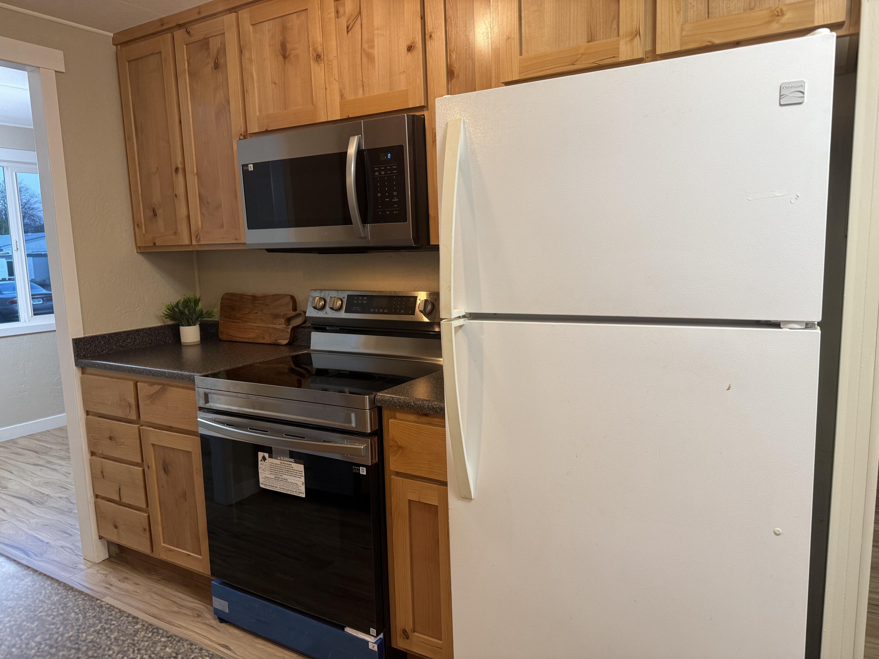 355 Colver Road, Unit 48 Talent, OR 97540 - Photo 3 of 30 a kitchen with a refrigerator and a microwave