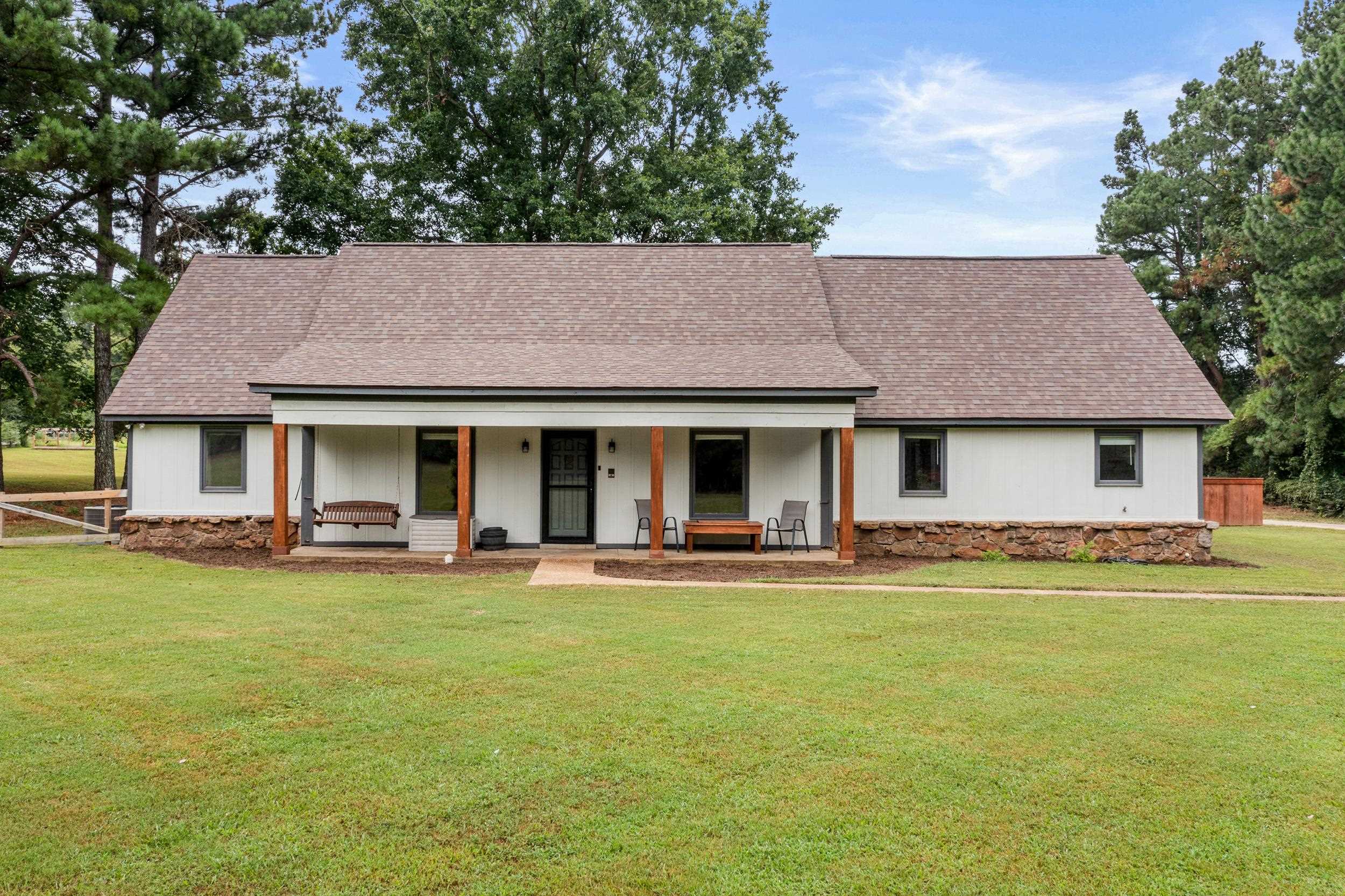 Ranch-style house with covered porch and a front lawn