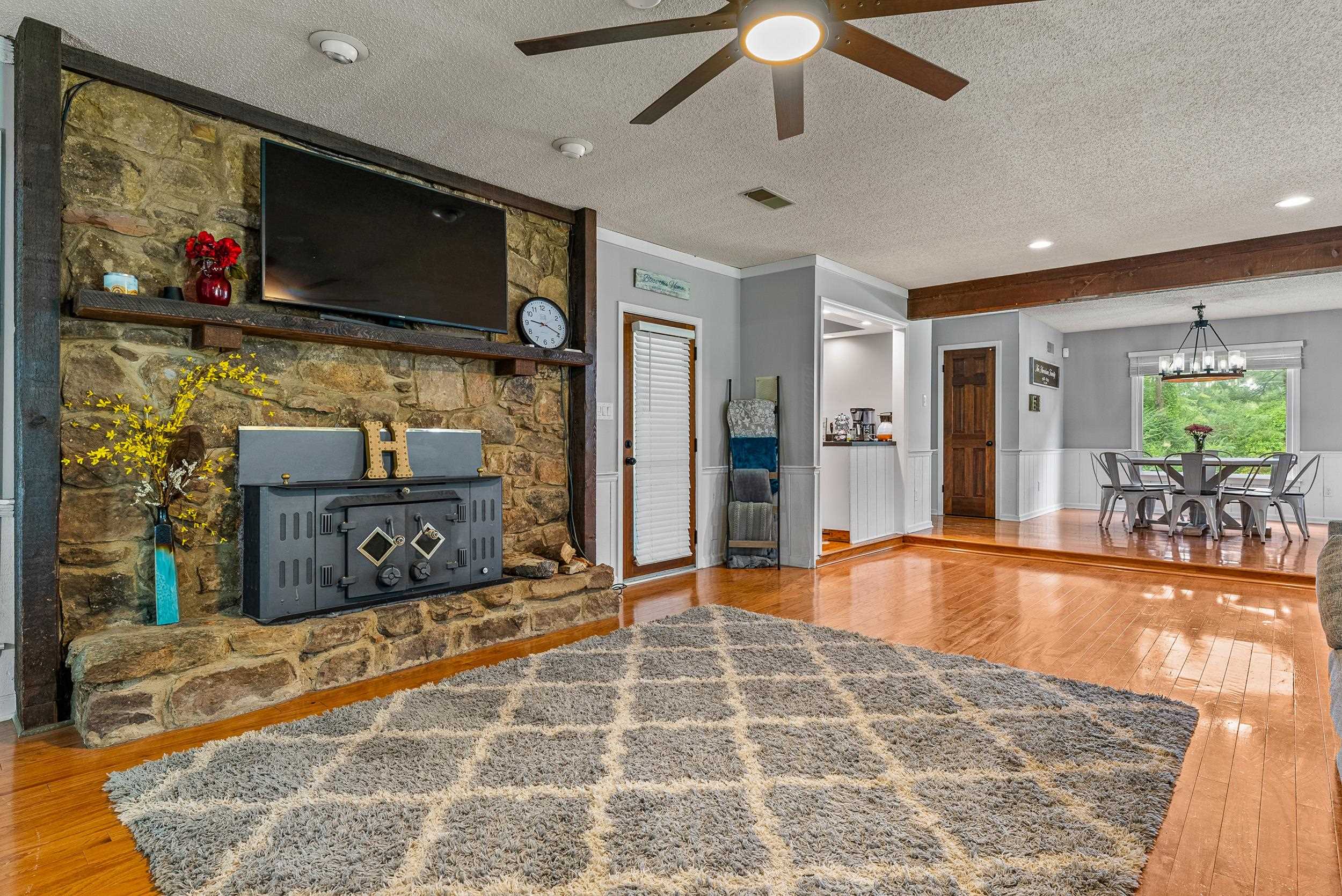 12389 Macon Road Collierville, TN 38017 - Photo 18 of 37 Living room with ceiling fan with notable chandelier, a textured ceiling, and wood-type flooring