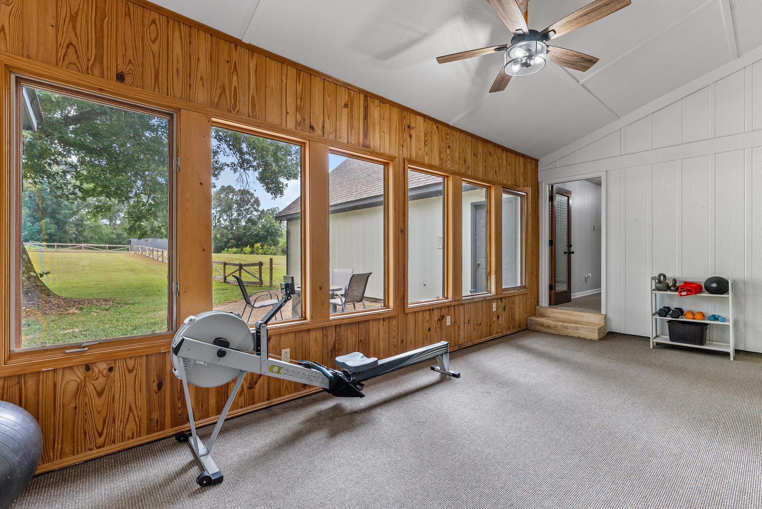 12389 Macon Road Collierville, TN 38017 - Photo 22 of 37 Workout area featuring ceiling fan, wood walls, vaulted ceiling, and carpet floors