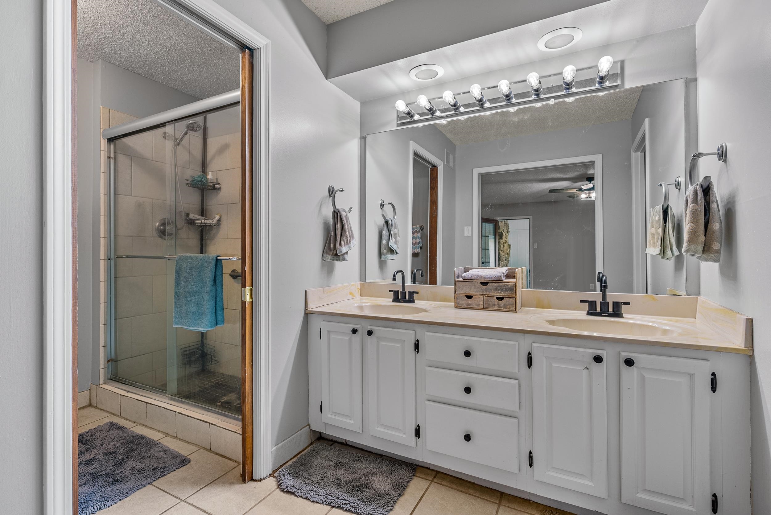 12389 Macon Road Collierville, TN 38017 - Photo 26 of 37 Bathroom featuring ceiling fan, tile patterned floors, a shower with door, and dual vanity