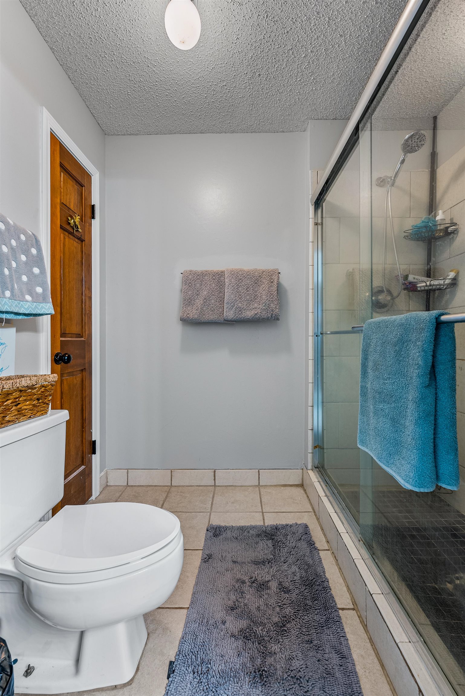 12389 Macon Road Collierville, TN 38017 - Photo 27 of 37 Bathroom featuring a shower with door, a textured ceiling, tile patterned flooring, and toilet