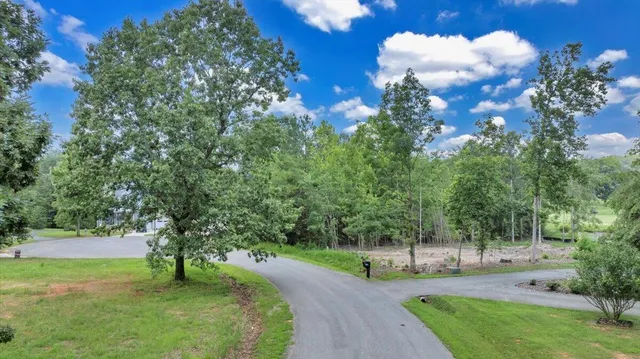 a large kitchen with stainless steel appliances kitchen island granite countertop a refrigerator a oven a island and a stove with wooden floors