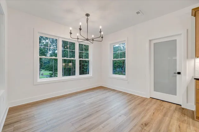 a view of a kitchen with wooden floor and electronic appliances