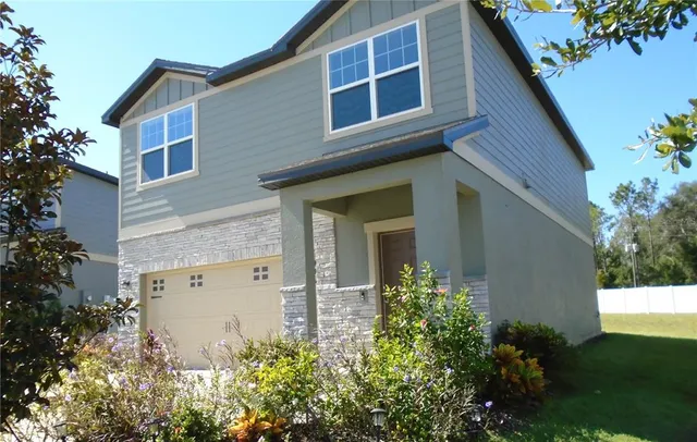 a view of a house with yard and garage