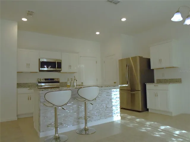 a kitchen with refrigerator and microwave