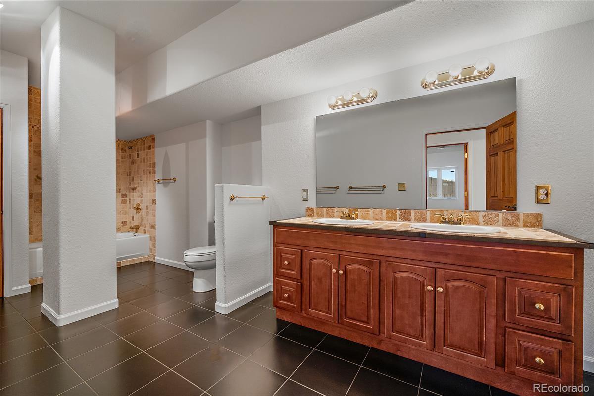 1305 South Grapevine Road Golden, CO 80401 - Photo 35 of 39 a spacious bathroom with a granite countertop sink and a mirror