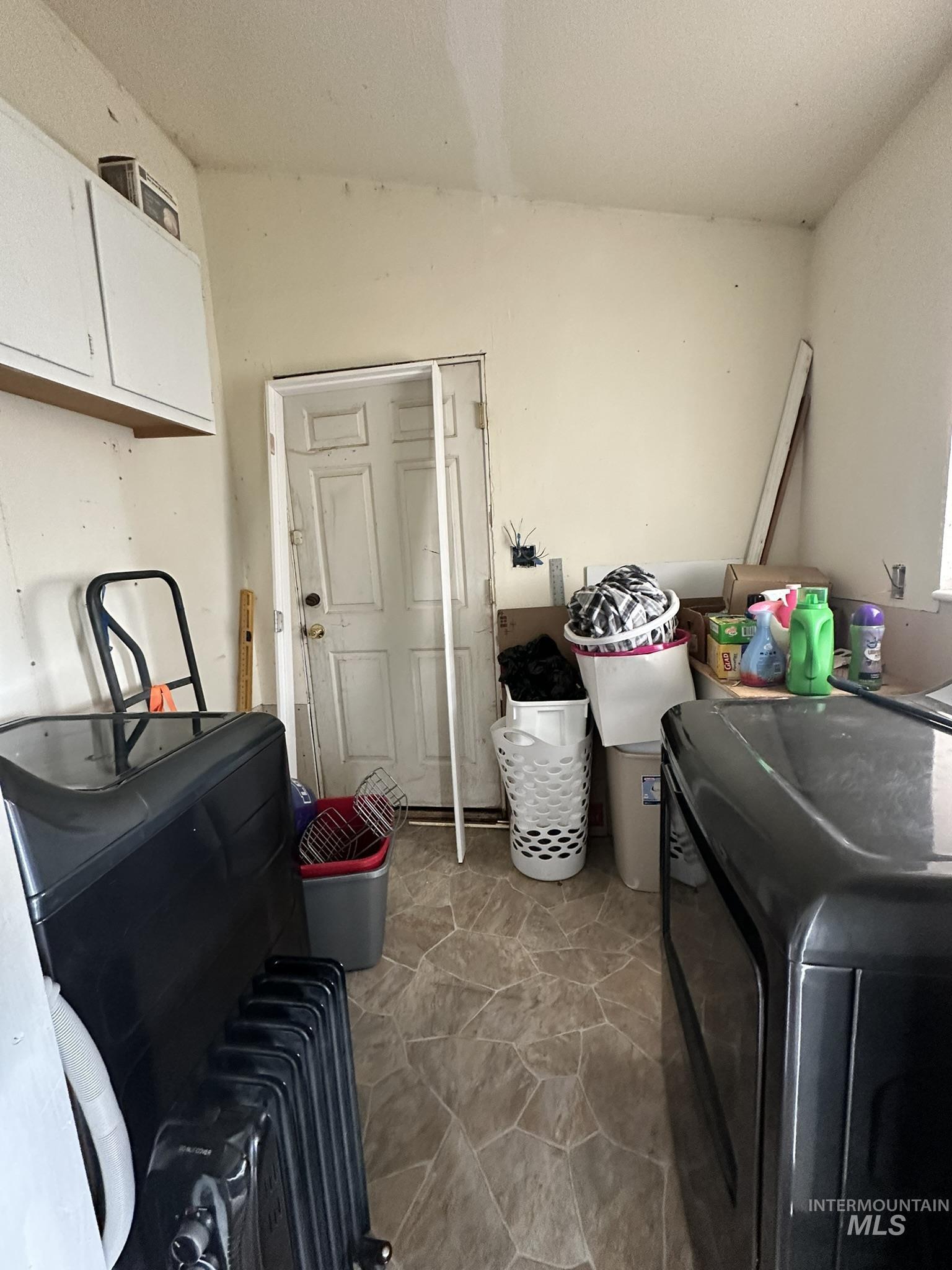 6750 Dearborne Road Nampa, ID 83686 - Photo 15 of 26 Laundry room with light stone finish flooring, radiator, and a textured ceiling